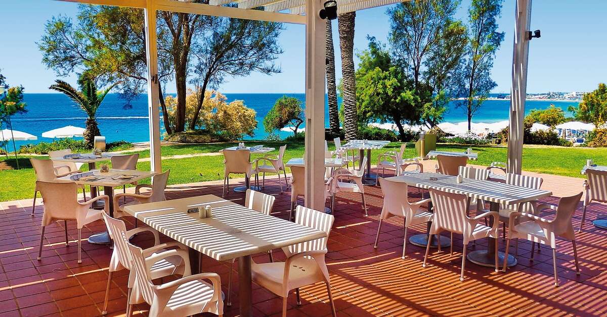 Een foto van het terras bij Grecian Sands Hotel