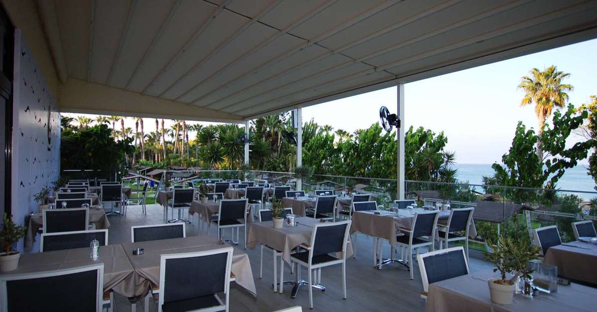 Een foto van het terras bij Cavo Maris Beach Hotel