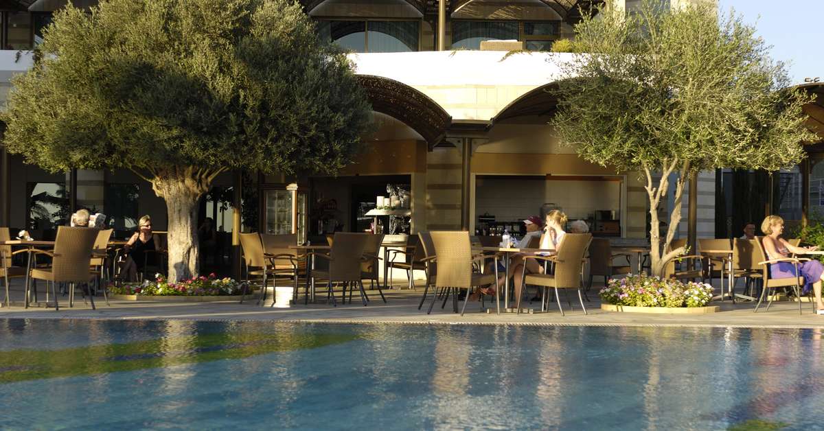 Een foto van het terras bij Constantinou Bros Athena Royal Beach Hotel