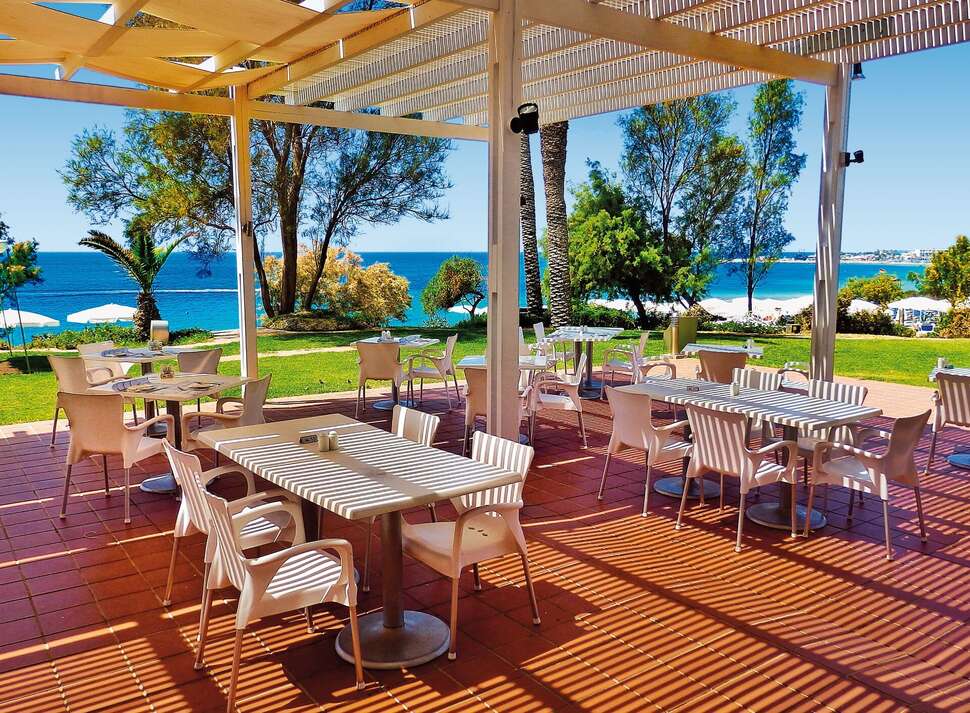 Een foto van het terras bij Grecian Sands Hotel
