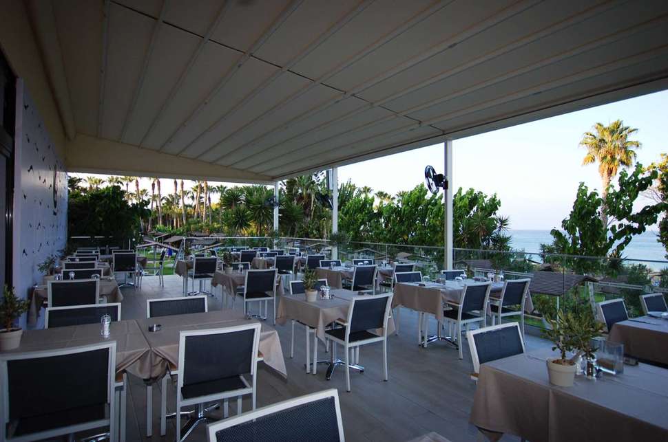 Een foto van het terras bij Cavo Maris Beach Hotel